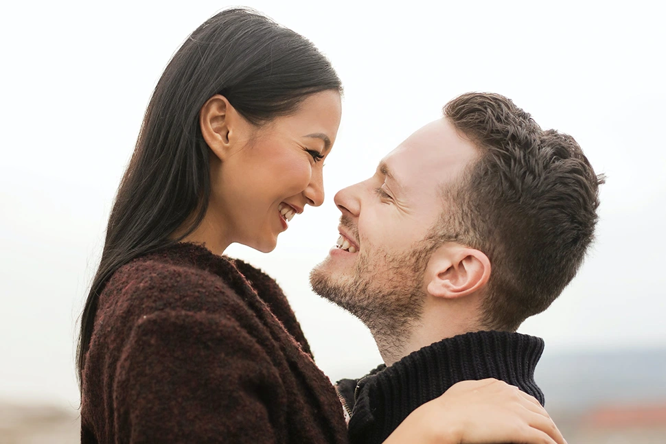 Woman looking down at man who is smiling up at her