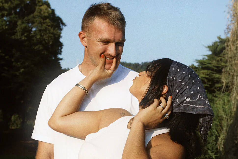 Couple smiling at eachother, thewoman is touching the mans face